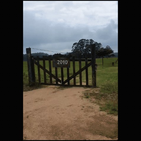 Portão de entrada do sítio com o número 2010, em estrada de terra.